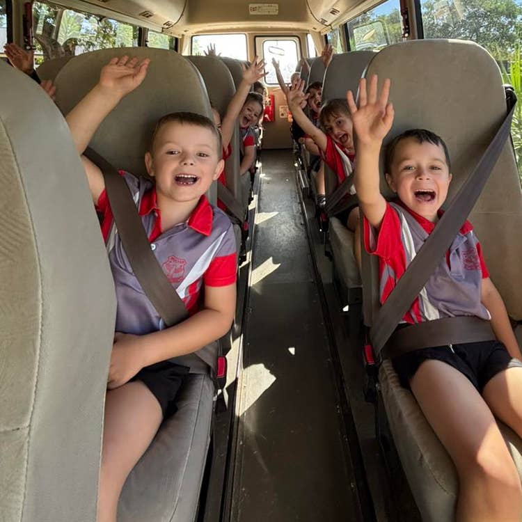 Our students heading off for an excursion on a mini bus cheering and waving at the camera