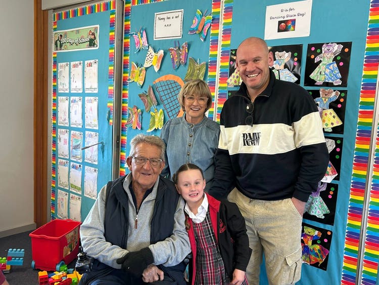 one of our families in a classroom, a student, her dad and her grandparents